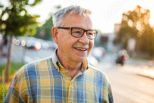 Portrait of happy senior man in the city.
