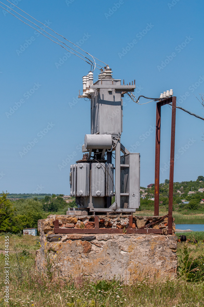 Electrical transformer on a stone stand. Old high-voltage power station.