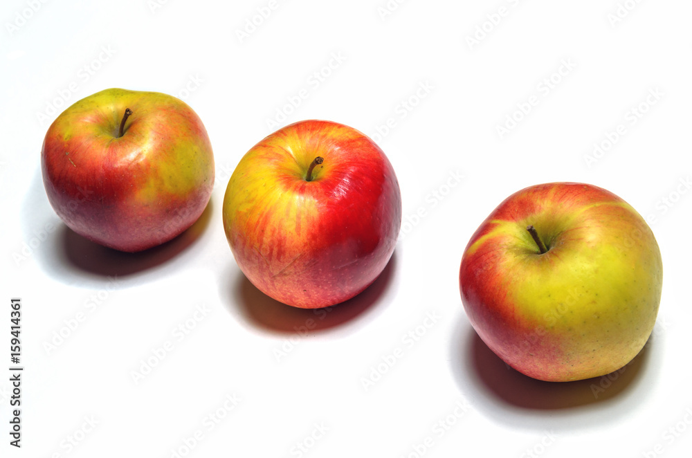 Three ripe apples on a white background