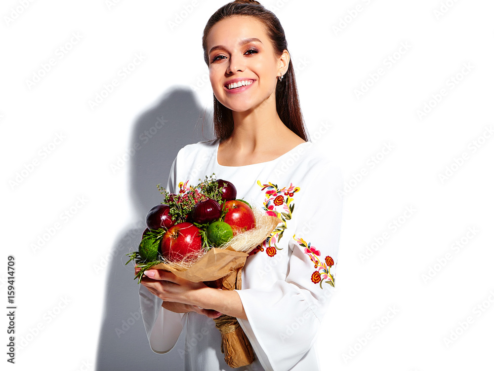 Portrait of beautiful caucasian smiling brunette woman model in white summer stylish dress with unusual creative bouquet of flowers isolated on white background Portrait of beautiful caucasian smiling brunette woman model in white summer stylish dress with unusual creative bouquet of flowers isolated on white background