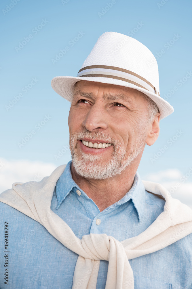 portrait of grey haired stylish man smiling and looking away