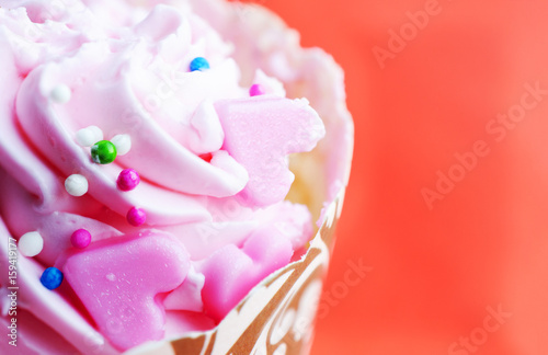 Close up of heart shaped with cup cake dessert on red pastel backgrounds