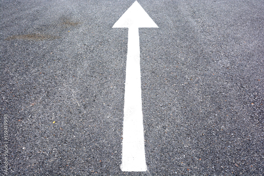 white arrow sign on the dry soil, ground, background white arrow sign on the dry soil, ground, background
