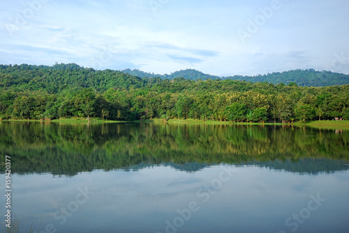 Cityscape green forest and blue sky reflection on the water river in national park in Thailand