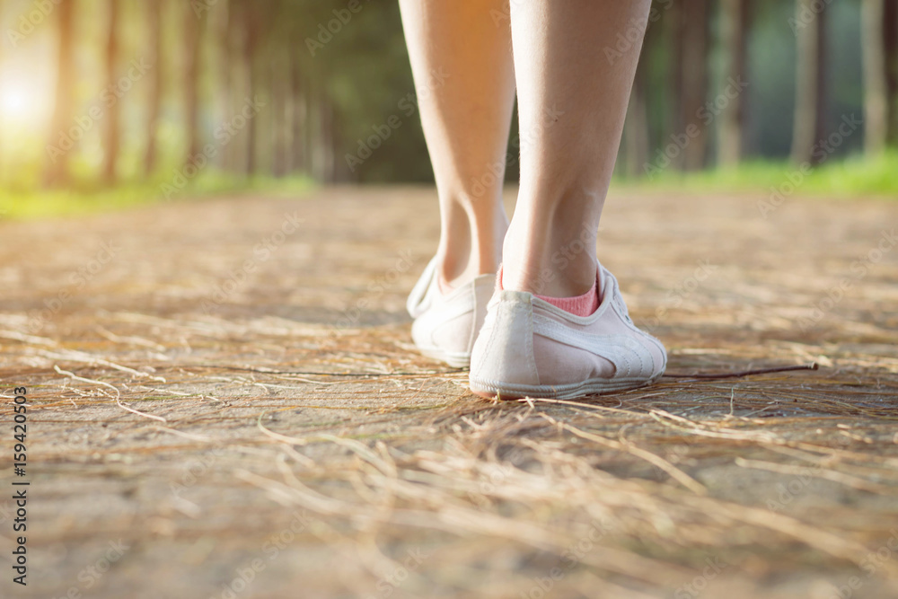 young woman legs wallking on the  road in park