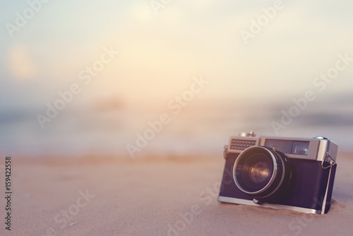 Vintage camera is located on the beach.