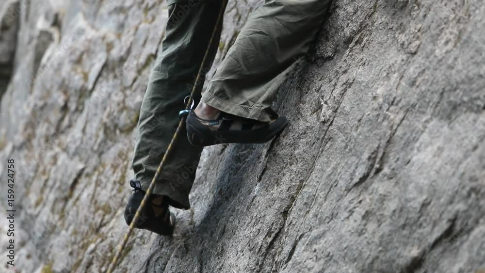 Detail of strong healthy young rock climbing man, legs and feet