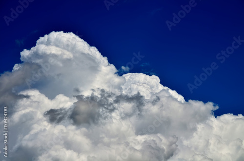 Blue sky with white and gray cumulus clouds. Closeup