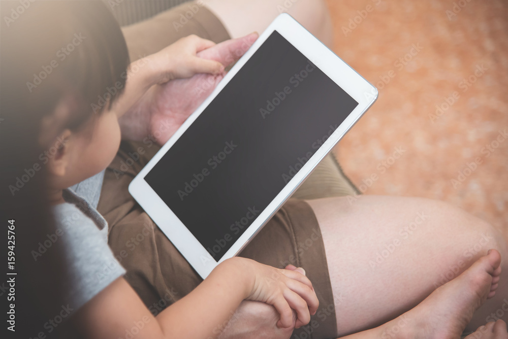 Asian little kid girl and her family sitting and using digital tablet together. Asian little kid girl and her family sitting and using digital tablet together.