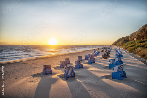 Fototapeta Naklejka Na Ścianę i Meble -  Schatten von Strankörben beim Sonnenaufgang am Strand