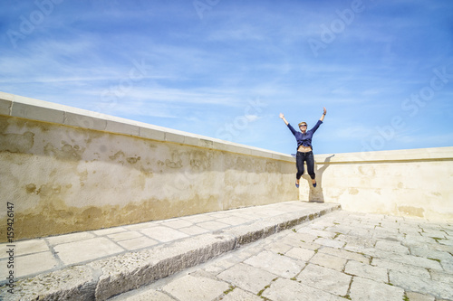 Happy woman jumping in the corner of the terrace