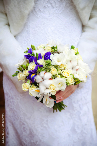 Bridal bouquet. The bride's . Beautiful of white flowers and greenery, decorated with silk ribbon, lies on vintage wooden chair