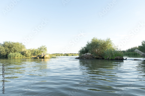 Channel landscape with waves in Danube Delta, Romania, on summer day photo