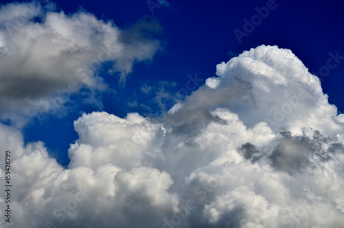 Blue sky with white and gray cumulus clouds. Closeup