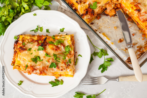 Piece of traditional Italian meat lasagna on a white plate.