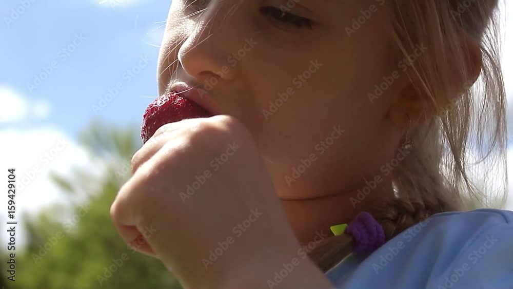 Little girl enjoying eating strawberry. A funny little girl 5 years old with a strawberries. Little girl enjoying eating strawberry. A funny little girl 5 years old with a strawberries.
