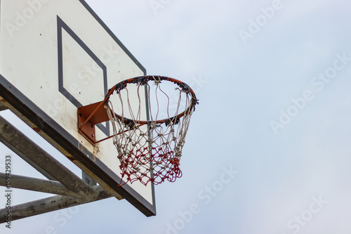 Old wooden basketball hoop with blue sky used for long time  