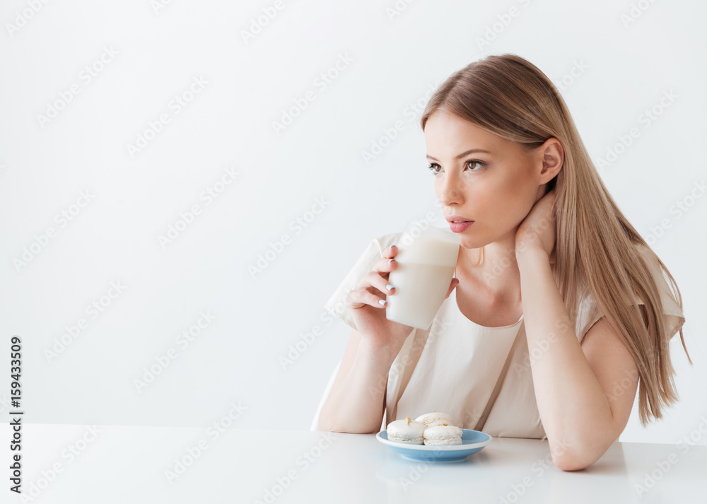 Lady sitting isolated near sweeties drinking coffee Lady sitting isolated near sweeties drinking coffee
