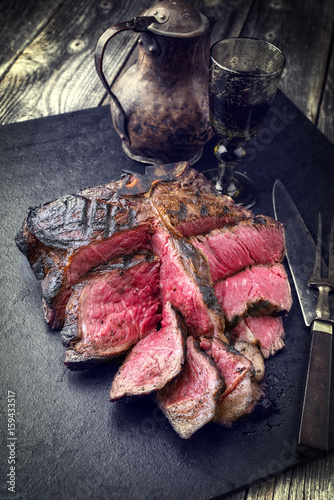 Barbecue dry aged Wagyu Bistecca alla Fiorentina as close-up on a black slate