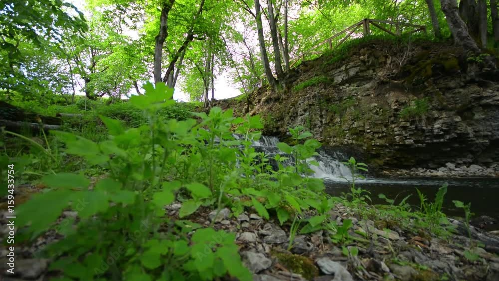 Slider shot of waterfall cascade on river flowing through summer forest. Nature landscape. Slider shot of waterfall cascade on river flowing through summer forest. Nature landscape.