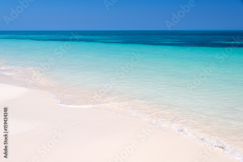 Sand and caribbean sea background, tropical beach travel concept © Delphotostock