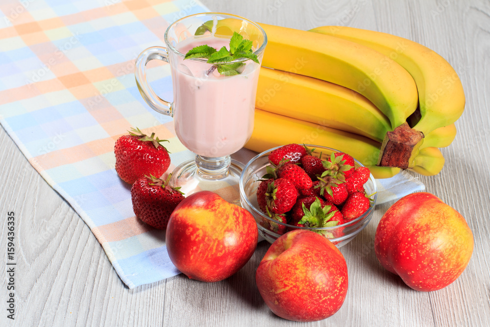 Glass of yogurt with mint and fresh strawberries, nectarine, banana on the table Glass of yogurt with mint and fresh strawberries, nectarine, banana on the table