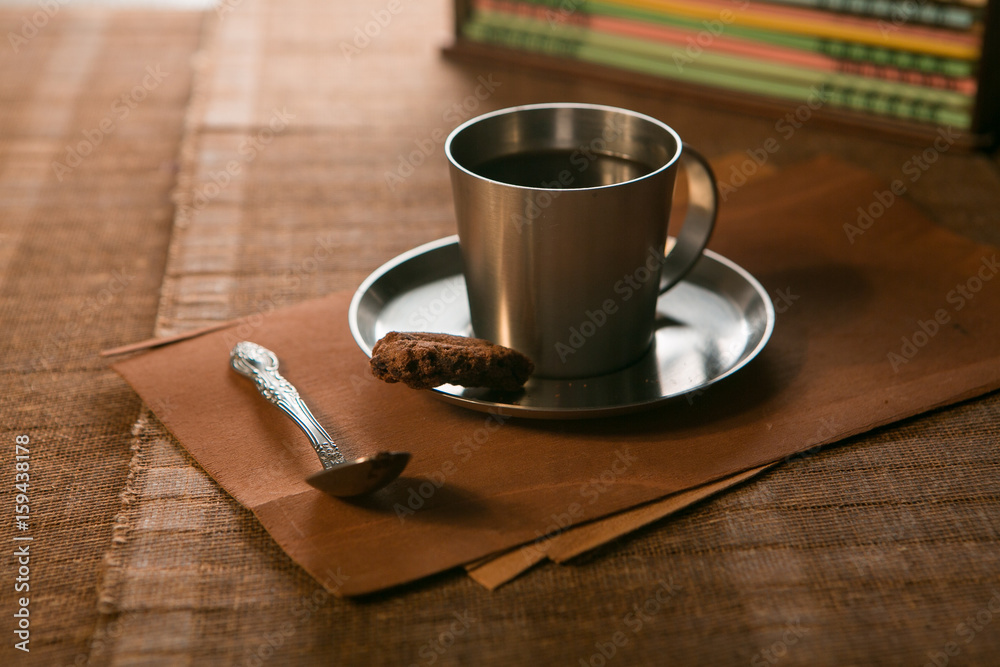 Obraz premium coffee Cup with spoon and biscuits on the background of notebooks