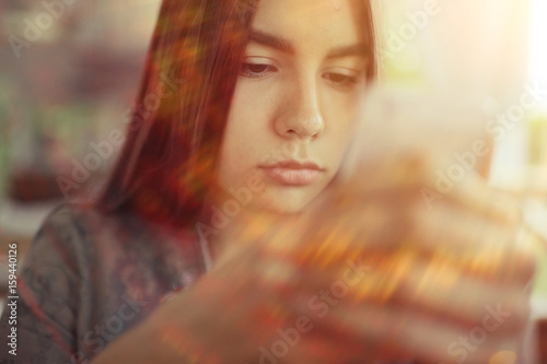 Girl with a phone in a cafe in the summer