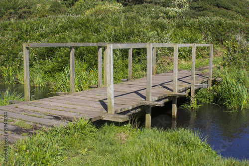 The remote wooden foot bridge on the Solent Way, Southampton Water at the end of the Hook Lane bridle path near Titchfield Common in Hampshire photo