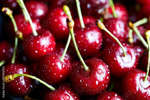 Sweet cherry lies on the table. Close-up photo, close-up. Drops of water on the surface of berries