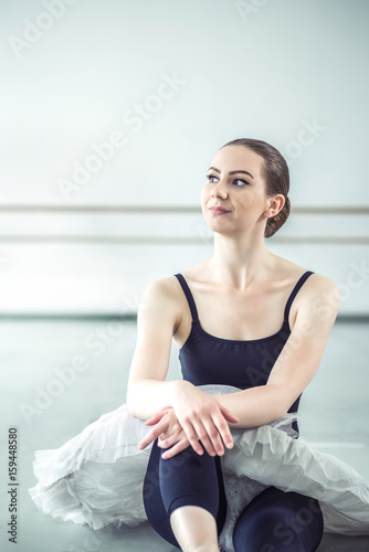 Bellerina sitting on the floor in ballet studio photo