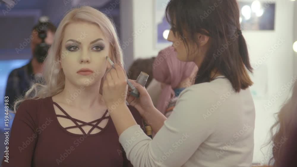 Makeup artist makes a girl beautiful makeup before photo shooting Makeup artist makes a girl beautiful makeup before photo shooting