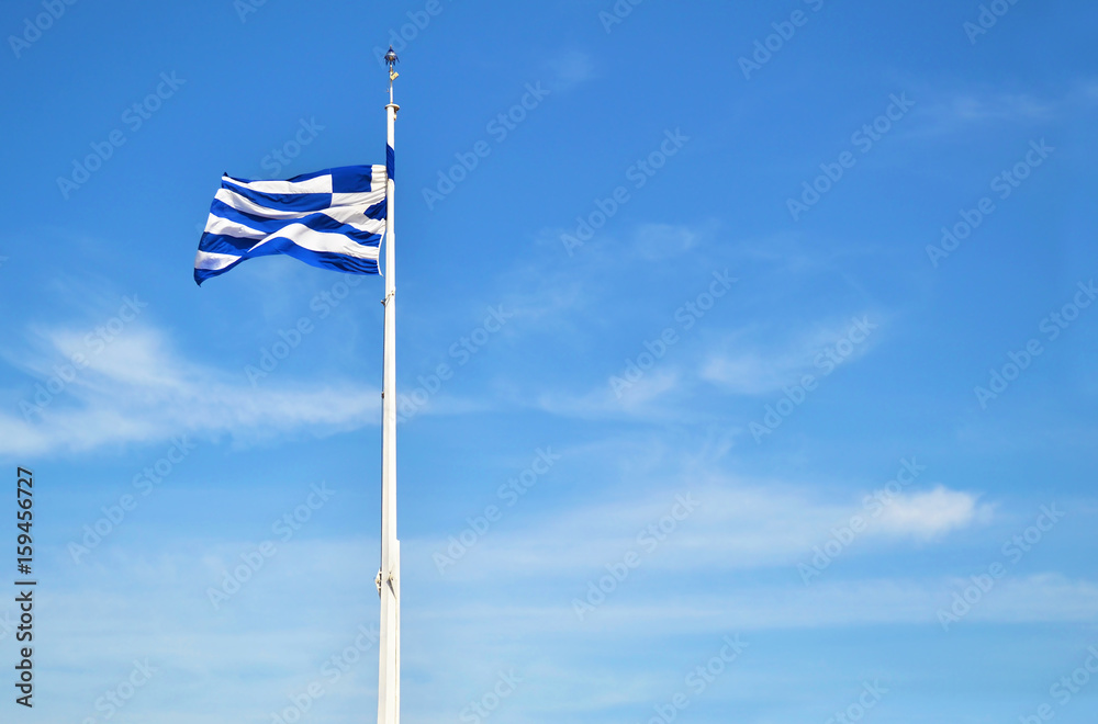 wavy greek flag with blue sky background at Acropolis Athens Greece