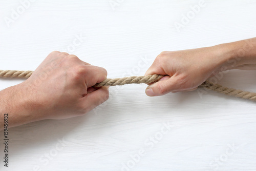  tug of war/ Hands pull a thick rope in different directions