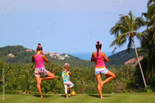 Yoga for children and adults on the grass with a beautiful view