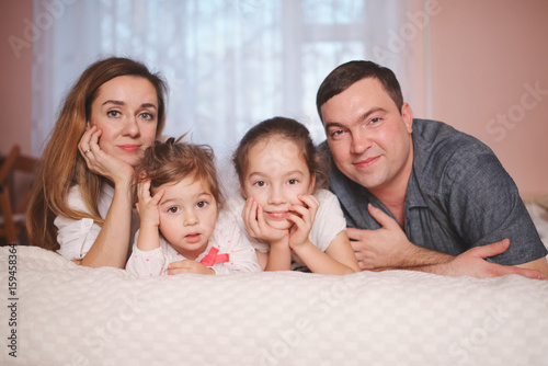 young family lying in bed at home