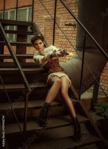 A girl in the style of steampunk flirts. The background is unusual metal constructions, factory pipes. Creative colors.