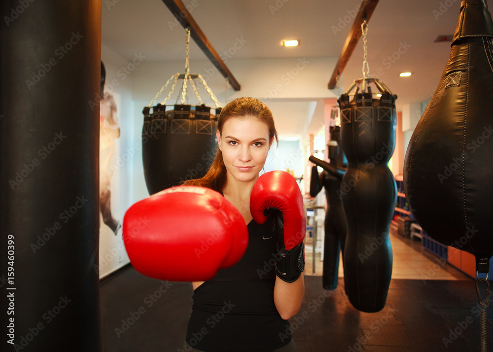 Sports young woman in boxing red gloves in gym