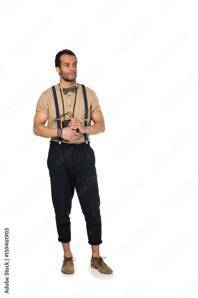 Full length view of stylish young african american man holding instant camera and looking away Full length view of stylish young african american man holding instant camera and looking away