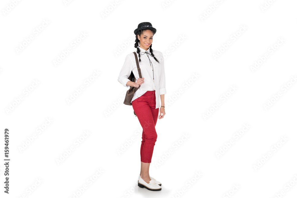 Full length view of stylish young woman standing with leather bag on shoulder and smiling at camera Full length view of stylish young woman standing with leather bag on shoulder and smiling at camera