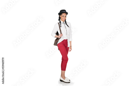 Full length view of stylish young woman standing with leather bag on shoulder and smiling at camera © LIGHTFIELD STUDIOS