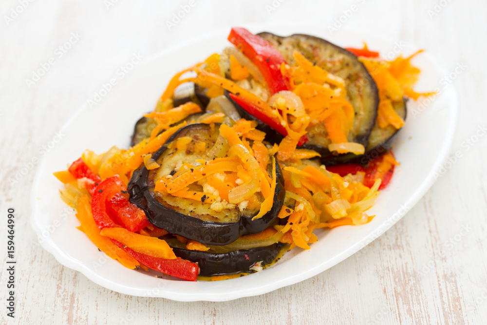 fried eggplant with garlic, carrot and red pepper on white dish fried eggplant with garlic, carrot and red pepper on white dish