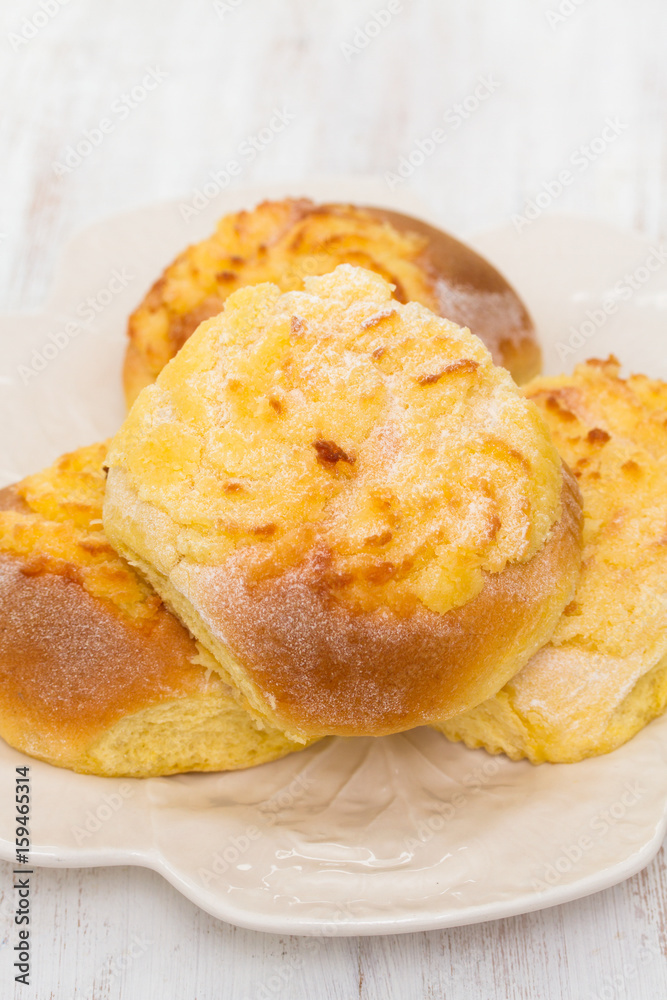 typical portuguese buns with coconut on white plate