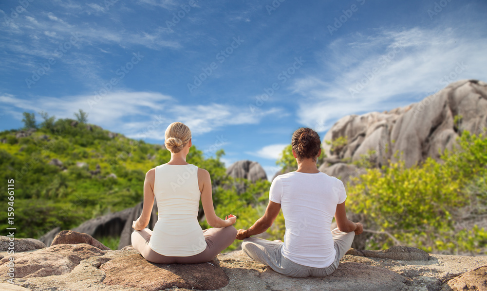couple meditating in yoga lotus pose outdoors