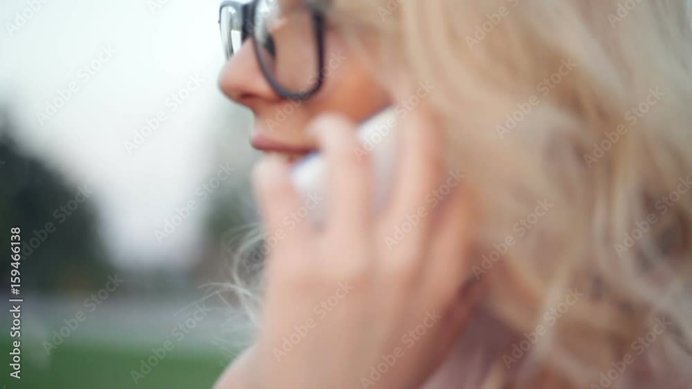 Beautiful young woman with glasses is talking on the phone Beautiful young woman with glasses is talking on the phone