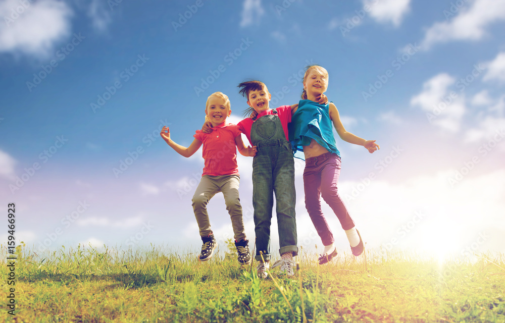 group of happy kids jumping high on green field group of happy kids jumping high on green field