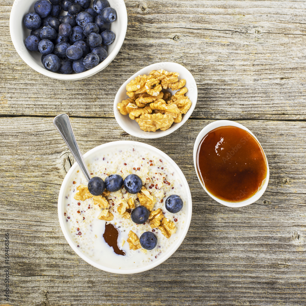 Sweet milk porridge quinoa with honey and walnuts. Top view Sweet milk porridge quinoa with honey and walnuts. Top view