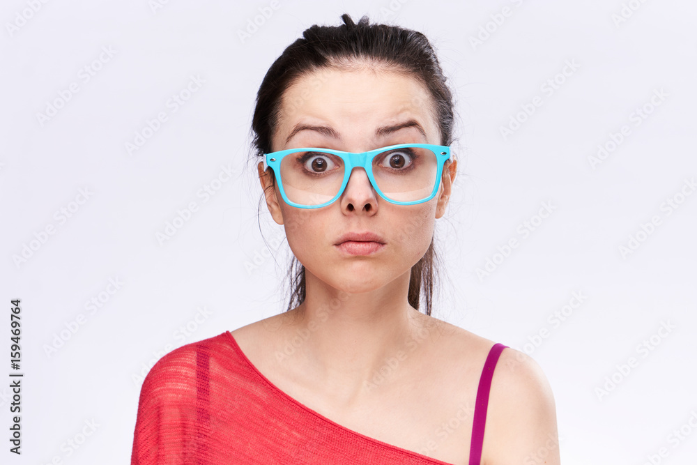 Surprised woman with glasses on a light background