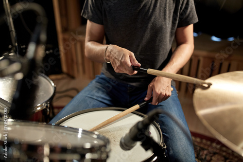 male musician playing drums and cymbals at concert