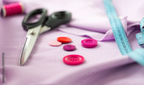 scissors, sewing buttons, tape measure and cloth